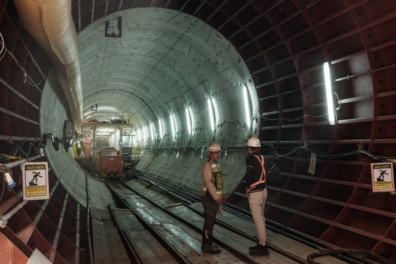 Workers talk at the end of the tunnel construction site with a tunnel boring machine for the Mass Rapid Transit MRT Phase 2 project